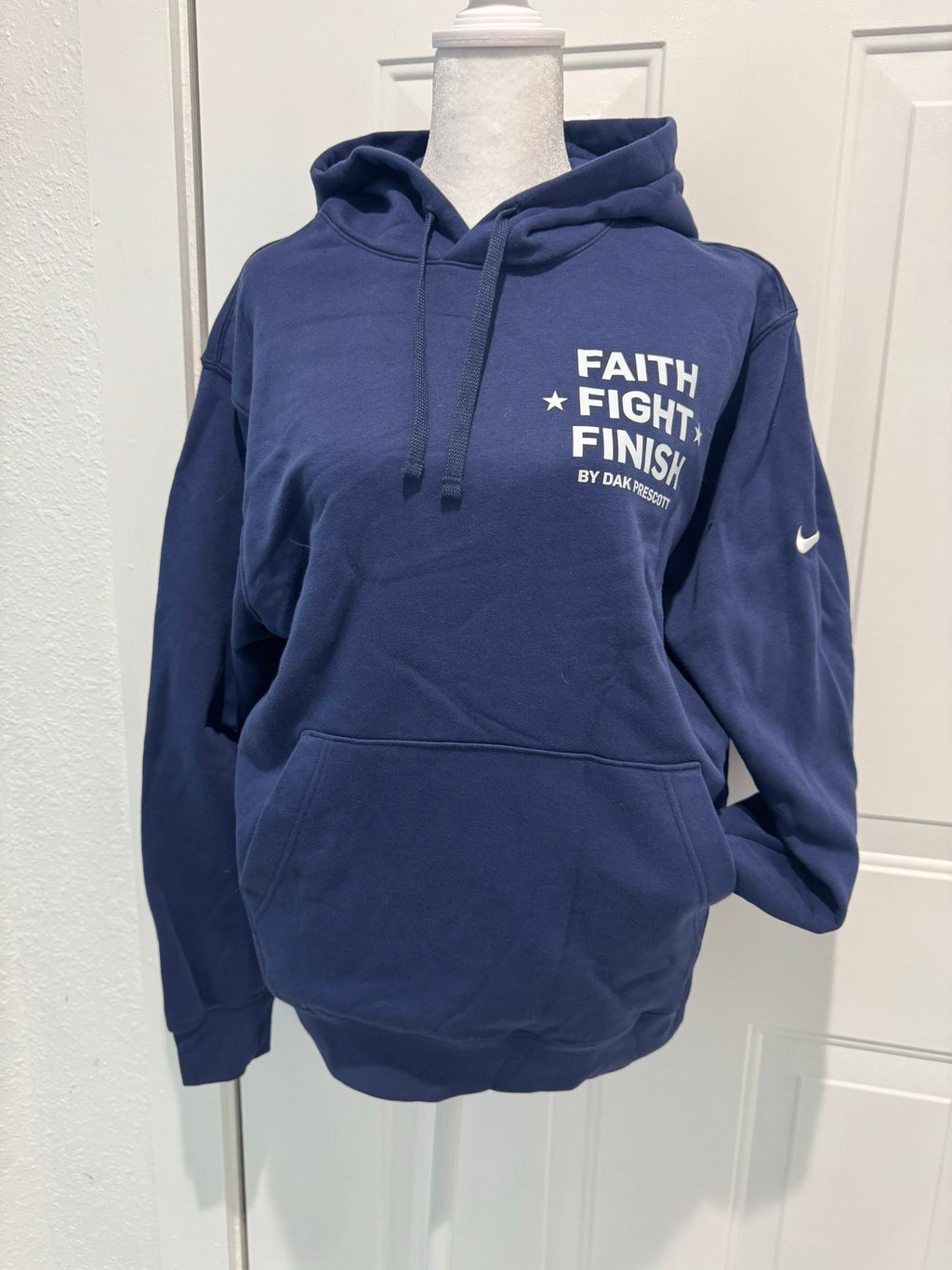 Navy blue hoodie with 'Faith Fight Finish' text on a mannequin against a white wall.