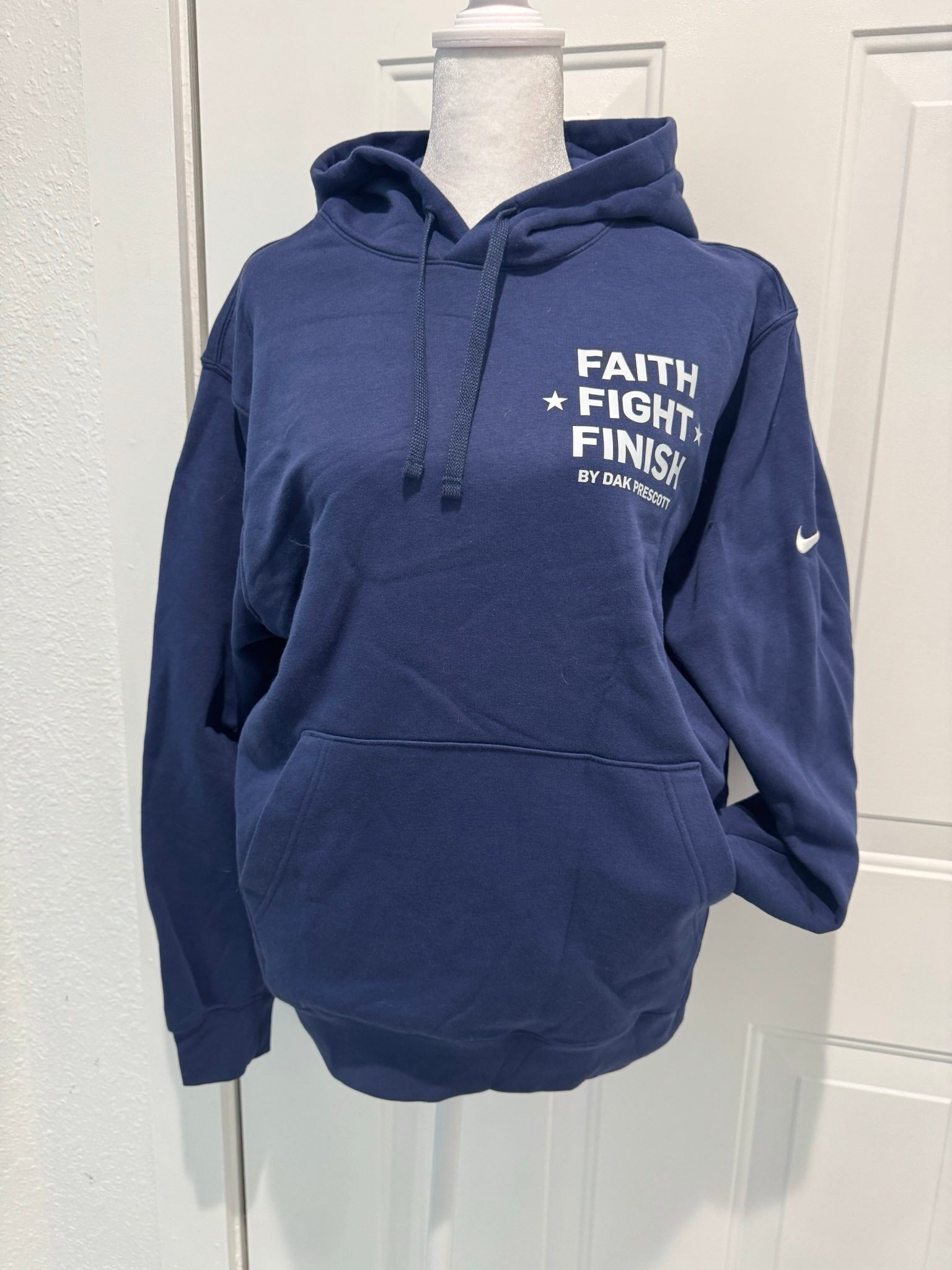 Navy blue hoodie with 'Faith Fight Finish' text on a mannequin against a white wall.